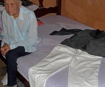 Leocádio Rodrigues de Lima, de 111 anos, ao lado da roupa que quer usar no próprio velório 