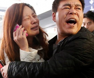 Parente de passageiro do voo MH370 da Malaysia Airlines chora enquanto fala no celular no Aeroporto Internacional de Pequim, China, neste sábado (8). O voo que ia de Kuala Lumpur a Pequim, na China, está desaparecido. Aeronave levava 239 pessoas a bordo.