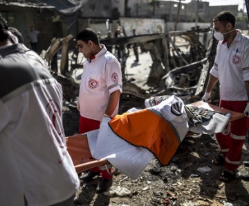 Palestinos carregam o corpo carbonizado de um motorista de ambulância, morto na noite de sexta-feira em Beit Hanun, em Gaza; na manhã deste sábado, teve início trégua de 12 horas