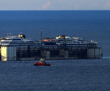 Navio Costa Concórdia é rebocado perto do porto de Gênova, na Itália, onde será atracado e desmontado
