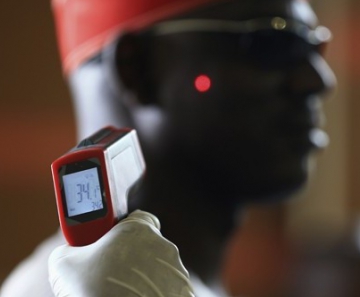Homem tem a temperatura aferida em termômetro digital no aeroporto internacional de Abuja, na Nigéria 