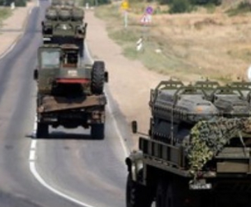Veículos militares russos carregados com porta-mísseis para navios passam por estrada em província da Rússia na fronteira com a Ucrânia. 