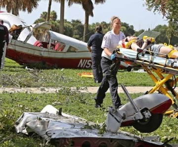 Um dos passageiros do avião que caiu no parque Vinoy nesta segunda (15) é levada para atendimento médico 
