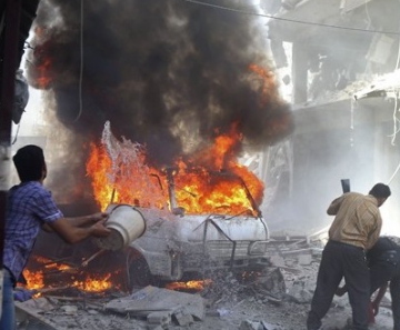 Moradores tentam apagar incêndio após ataques na região central de Douma, perto de Damasco