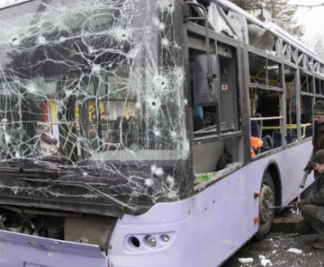 Pessoas cercam ônibus que foi atingido por morteiro em Donetsk nesta quinta-feira (22), deixando mortos 
