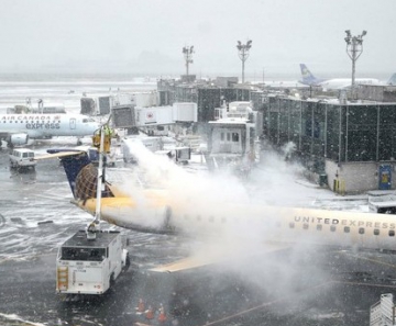 Funcionários retiram gelo de avião no aeroporto de LaGuardia, em Nova York. Vários voos foram cancelados por causa da nevasca que atinge a Costa Leste dos EUA. 