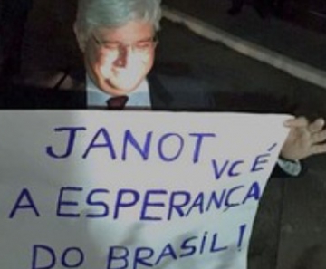 Janot segura cartaz levado por manifestantes à PGR 