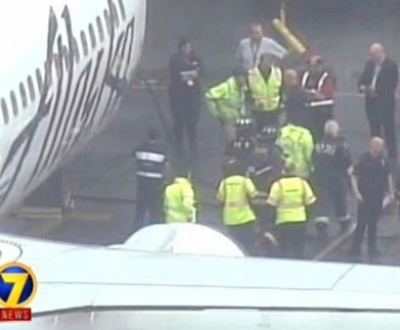 Funcionário da Menzies Aviation é retirado da área de carga de avião da Alaska Airlines nesta segunda-feira (13) após a aeronave realizar um pouso de emergência 