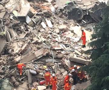 Equipes de resgate trabalham nos destroços de um prédio que desabou na China