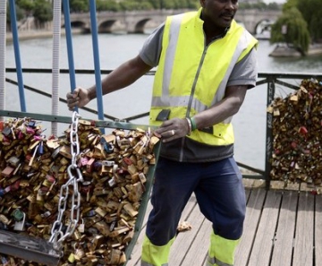Um trabalhador remove os 'cadeados do amor' da Pont des Arts em Paris, na França. O ritual começou com turistas em 2008 e logo se espalhou para cidades como Nova York, Seul e Londres. Cerca de 1 milhão de cadeados pesando 45 toneladas serão removidos 