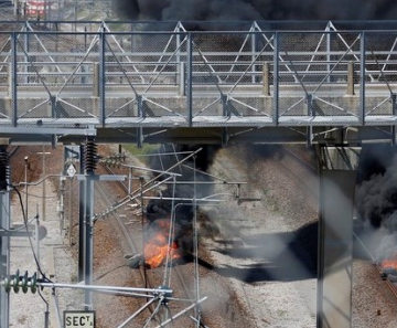 Pneus são incendiados sobre os trilhos na entrada do Eurotúnel perto de Calais, na França 