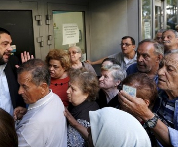 Pensionistas gregos se espremem em filas para sacar parte de seus benefícios 