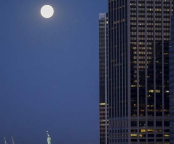 Lua azul, chamada assim por ser a segunda lua cheia do mês, é vista perto da Estátua de Liberdade, em Nova York, nesta sexta-feira (31) 