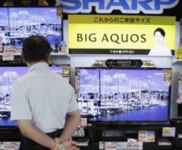 Homem observa televisores da Sharp em uma loja de eletrônicos em Tóquio 