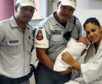 Ellen Ramos e a filha Isabela recebem a visita dos policiais que fizeram a parto na Marginal Tietê 