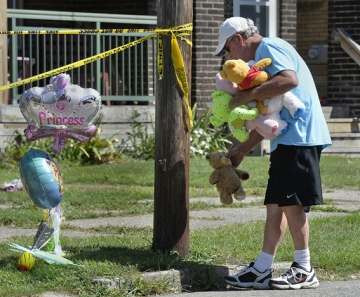 Homem deixa brinquedos em local onde 5 crianças morreram em incêndio na cidade de Erie, nos EUA — Foto: Greg Wohlford/Erie Times-News via AP