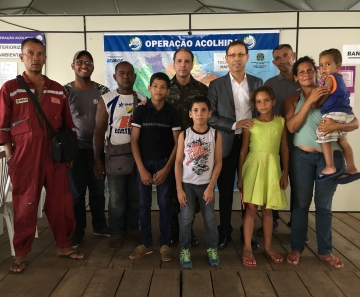 Bilionário Carlos Wizard (de paletó) acolhe venezuelanos recém-chegados ao Brasil