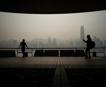 Turistas tiram fotos com a poluição atmosférica tomando o céu do famoso horizonte de Hong Kong. — Foto: Anthony Wallace/AFP/Arquivo