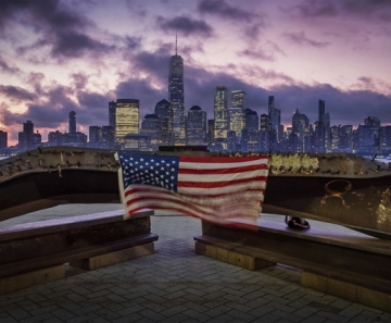 Uma bandeira dos EUA é vista sobre ferragem retorcida restante do ataque terrorista às Torres Gêmeas em 2001, em Jersey City, no dia que marca os 18 anos dos atentados de 11 de Setembro — Foto: J. David Ake/AP