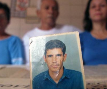 Em primeiro plano, foto de Aluízio Cavalcante Júnior, morto a tiros em 1987; em segundo plano estão (da esquerda para a direita): a mãe da vítima, a dona de casa Ana Dias, de 72 anos; o pai, o aposentado Aluizo, de 75; e a irmã dele, a diretora Janete, 48