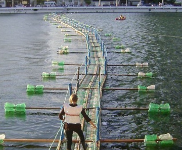 Visitante faz travessia sobre ponte feita de garrafas plásticas no Açude Velho, em Campina Grande