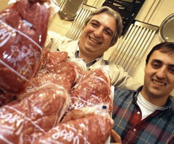 Marcos Bassi (à esq.) exibe peça de carne com a marca de seu açougue no Bixiga