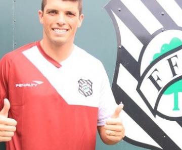 Tiago Volpi posa com o novo uniforme de treino, com predominância na cor grená 