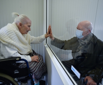 Suzanne Valette, de 88 anos e infectada com COVID-19, se encontra com seu filho Philippe Melard através de um vidro no lar de idosos Buissonets em Horion-Hozemont, uma seção do município de Grace-Hollogne, na Bélgica, em 29 de abril — Foto: John Thys/AFP